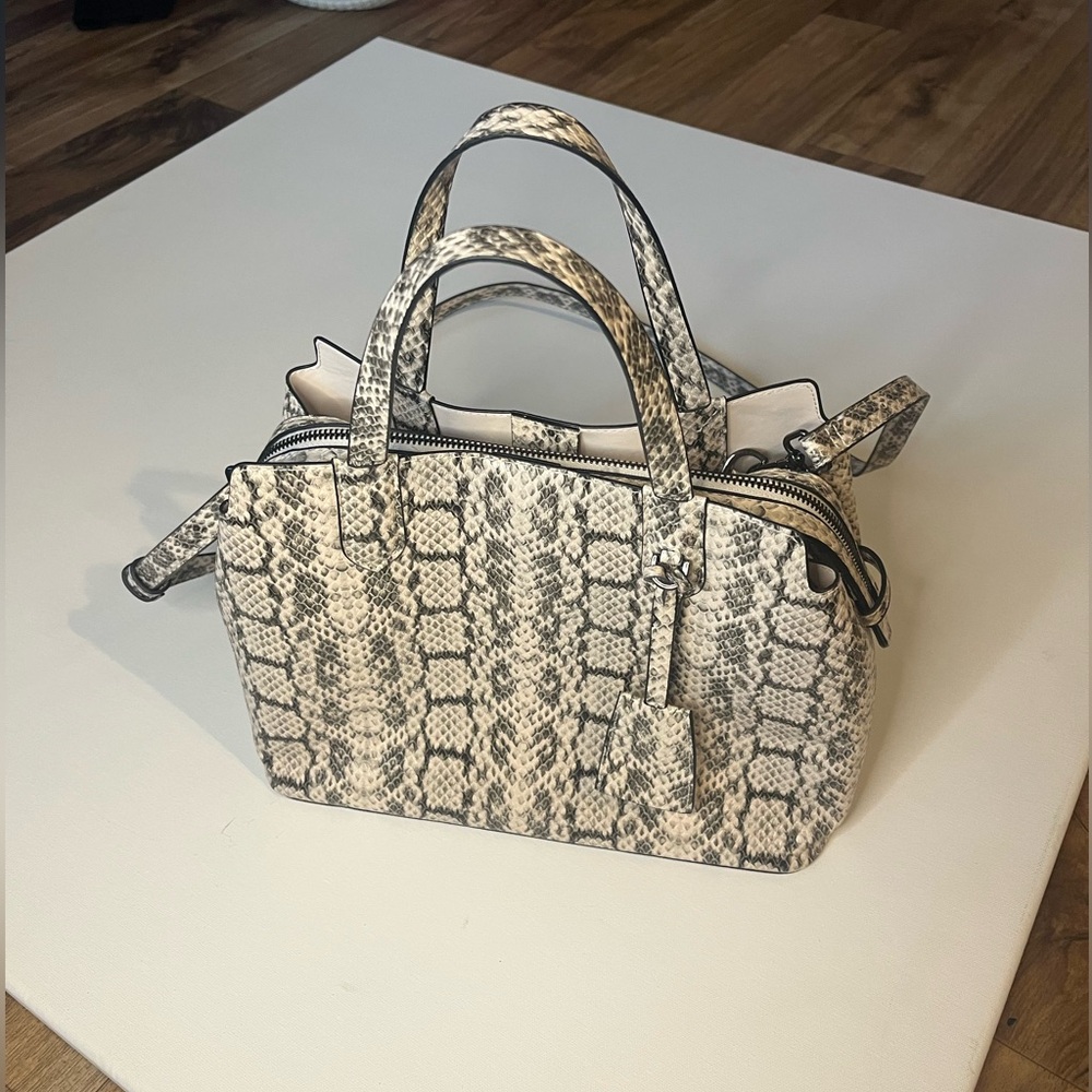 Snakeskin crossbody bag with multiple compartments.